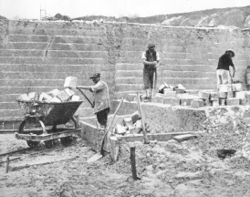 An open pit showing cubes of ball clay being cut vertically using a thirting iron